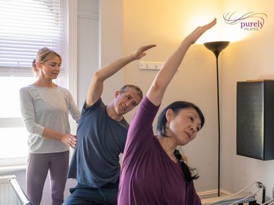 reformer pilates class, people leaning over